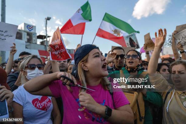 Protestors cuts her hair during a demonstration against the Iranian regime and in support of Iranian women, after young Kurdish Iranian woman Mahsa...