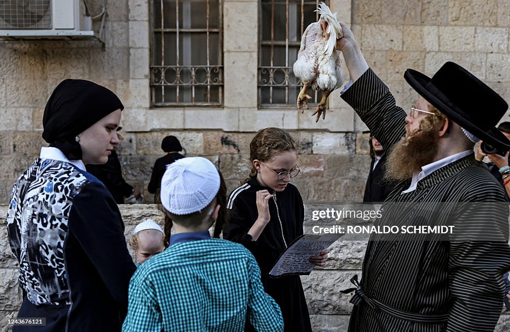 Kapporah Ritual An ultra-Orthodox Jewish man swings a chicken over the head of his ...