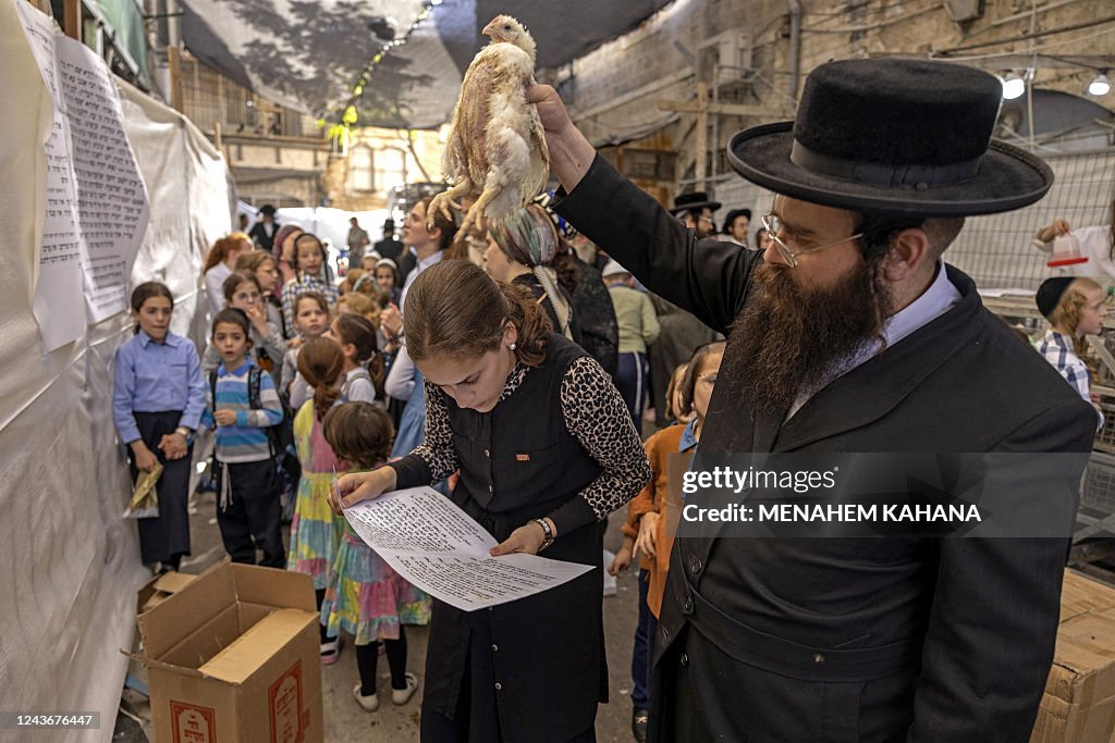 Kapporah Ritual An ultra-Orthodox Jewish man swings a chicken over the head of his ...