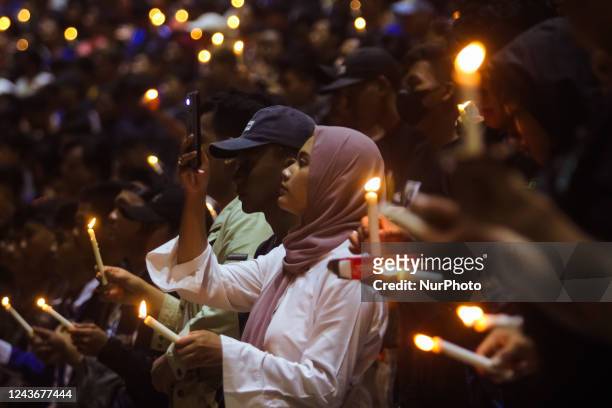 Football supporters gather and pray as a tribute to the victims of the riots in a soccer match at the Jatidiri Stadium in Semarang, Central Java...