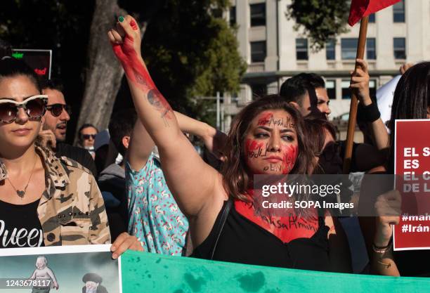 An Iranian woman with her body painted in red makes gestures during the demonstration following the death in custody of Masha Amini. Mahsa Amini died...