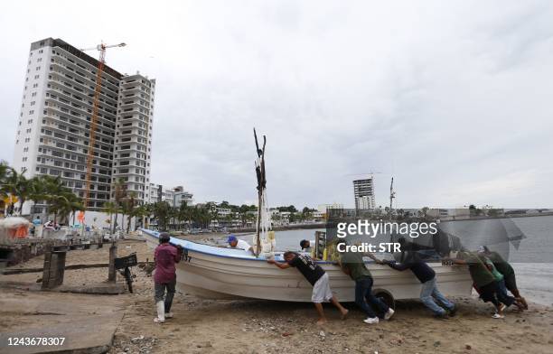 Fishermen take a boat out of the water ahead of the arrival of Hurricane Orlene, in Mazatlan, state of Sinaloa, Mexico, on October 2, 2022. -...