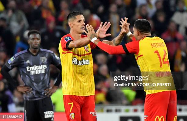 Lens' French forward Florian Sotoca celebrates with Lens' Argentinian defender Facundo Medina after scoring a goal during the French L1 football...