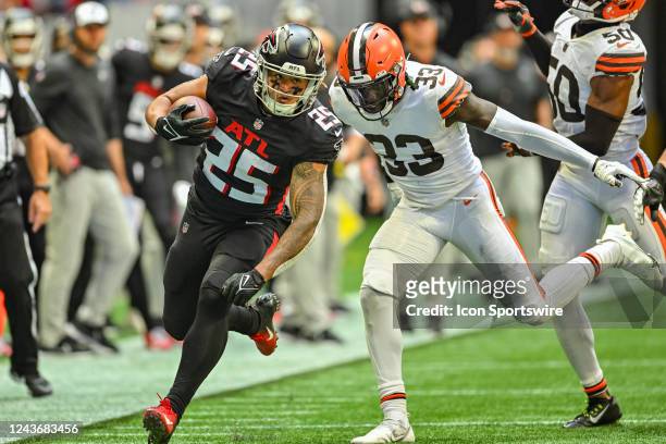 Atlanta running back Tyler Allgeier runs the ball as Cleveland safety Ronnie Harrison Jr. Pursues during the NFL game between the Cleveland Browns...