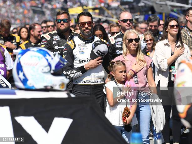 Aric Almirola along with his wife Janice and daughter Abby prepare for the National Anthem during pre-race activities before the running of the...