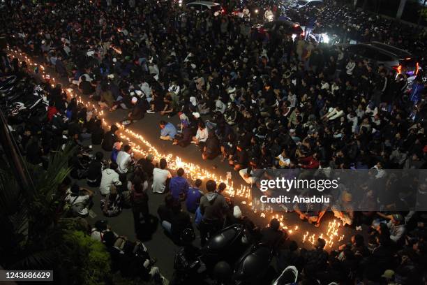 Residents and supporters of the Arema Malang FC light candles and pray together at the Gajayana Stadium, Malang, East Java, Indonesia on October 2,...