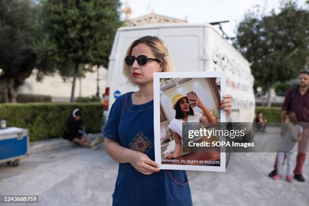 Protester holds a picture of a 23-year-old girl, Hananeh, who was shot and killed in Iran during a demonstration. Demonstrators were protesting...