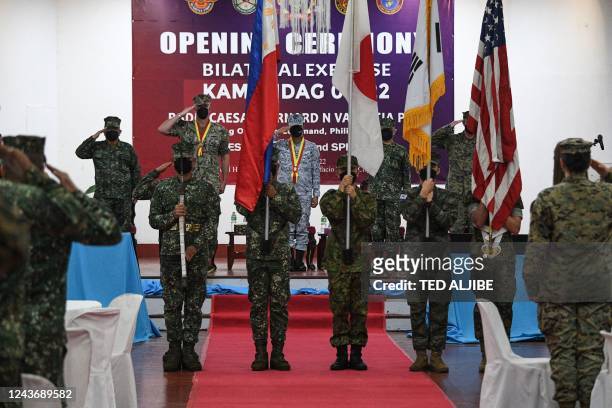 Philippine, US and South Korean marine and a member of the Japan Self-Defense Forces carry their national flags during the opening ceremony of...
