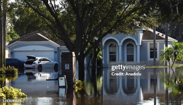 Water reflections of a home and a car are seen in a neighborhood that was flooded by rain from Hurricane Ian on October 1, 2022 in Orlando, Florida....