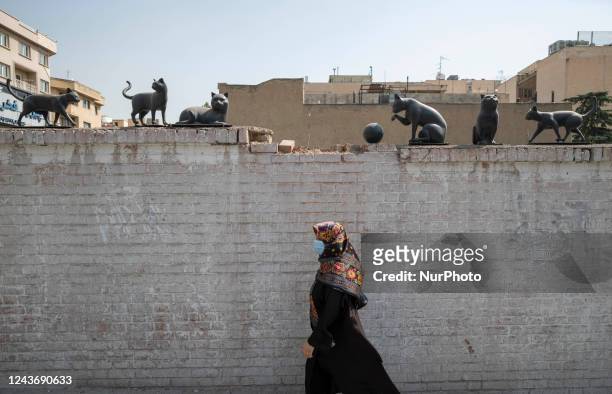 An Iranian woman walks past an urban art in Tehran, October 2, 2022.