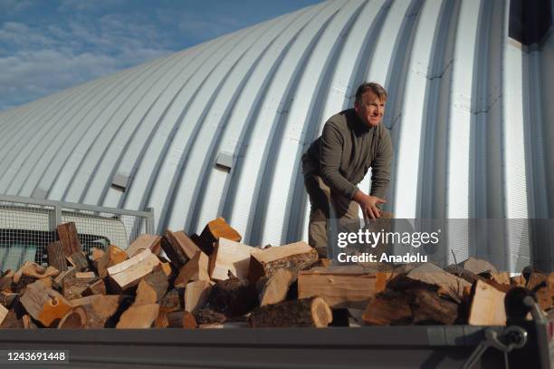 Site manager of the WH Danubius company is seen moving wood logs on the back of a trailer as firewood loggers in Eastern Slovakia are working at...