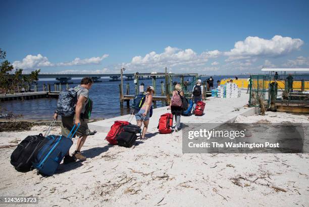 People walk toward a ferry boat to be evacuated from Sanibel Island, FL, on October 1 following Hurricane Ian.