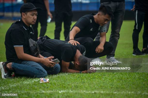 Players and officials from Arema Football Club gather to pray on the pitch for victims of the stampede at Kanjuruhan stadium in Malang, East Java on...