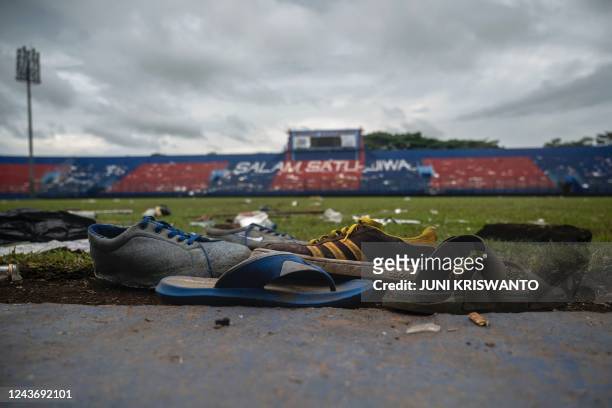 Discarded shoes sit by the pitch at Kanjuruhan stadium days after a deadly stampede following a football match in Malang, East Java on October 3,...