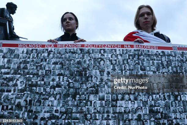 People hold a banner with Belarusian political prisoners photos during the meeting with Belarusian opposition leader Svetlana Tsikhanouskaya, at the...