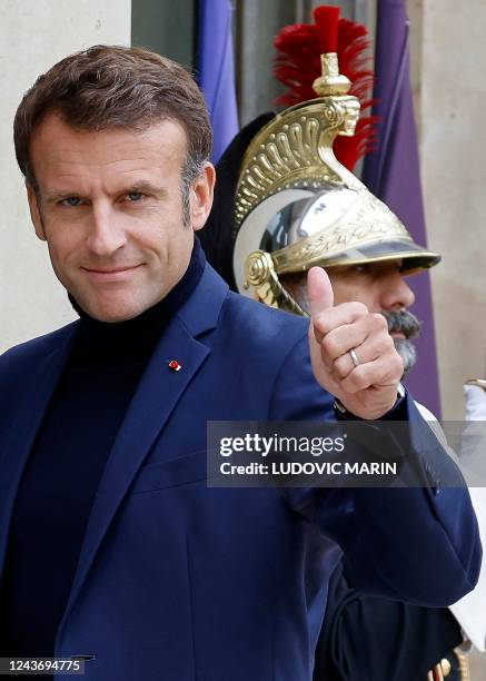 French President Emmanuel Macron, wearing a turtleneck jumper, gestures as he welcomes Guinea-Bissau's President at the Elysee Palace in Paris, on...