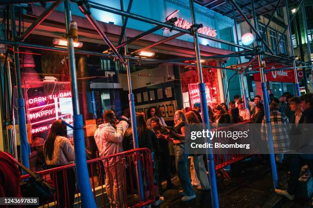 Customers wait in line to enter a cocktail bar in central London, UK, on Friday, Sept. 30, 2022. UK retailers are facing a mortgage time bomb, with...