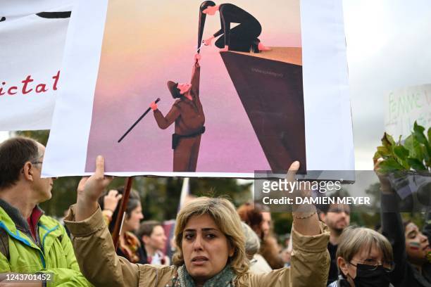 Protester holds a placard during a demonstration in support of Kurdish Iranian woman Mahsa Amini during a protest on October 3, 2022 in Nantes,...