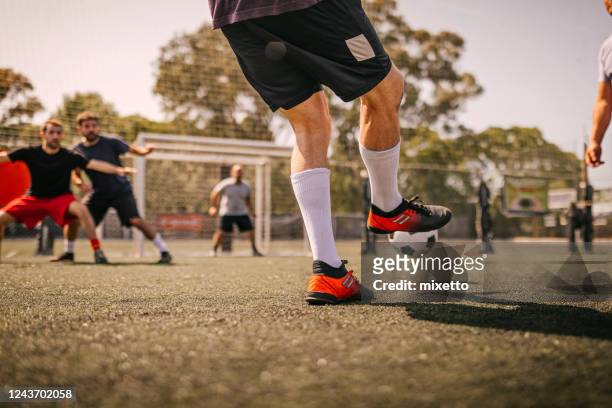 uomini che giocano a calcio - calciare foto e immagini stock