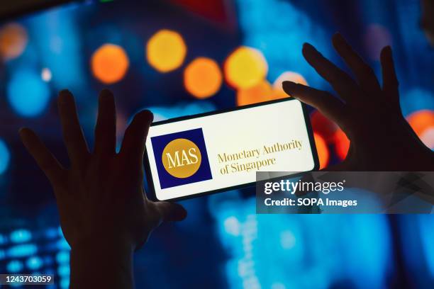 In this photo illustration, the Monetary Authority of Singapore logo is displayed on a smartphone.