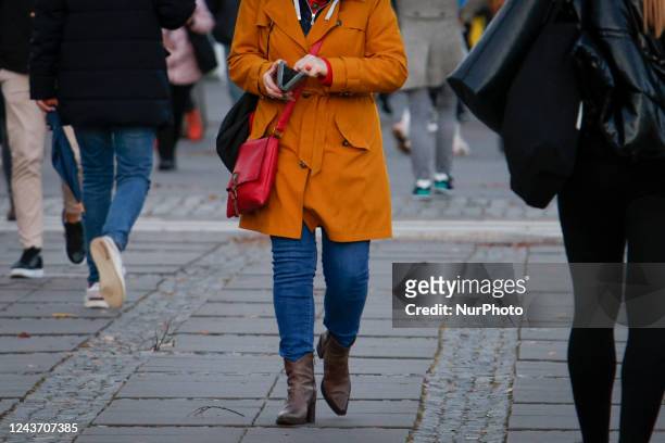 Woman is seen opening a wallet while walking in Warsaw, Poland on 03 October, 2022.