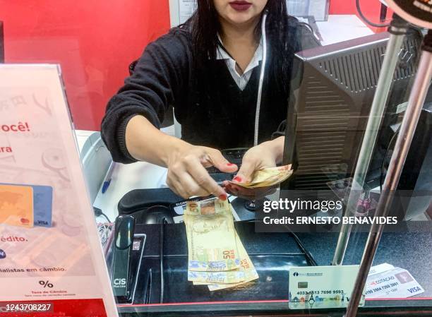 Woman delievers Brazilian Reais bills in a money exchange office in Sao Paulo, Brazil, on October 03, 2022. - Investors' optimism in Brazil drove the...