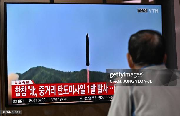 Man watches a television screen showing a news broadcast with file footage of a North Korean missile test, at a railway station in Seoul on October...