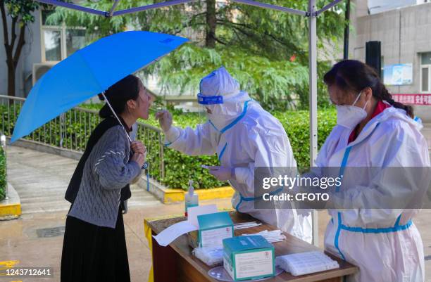 Medical staff carry out nucleic acid sampling work for residents during wind and rain in Yuncheng city, Shanxi Province, China, Oct 4, 2022.