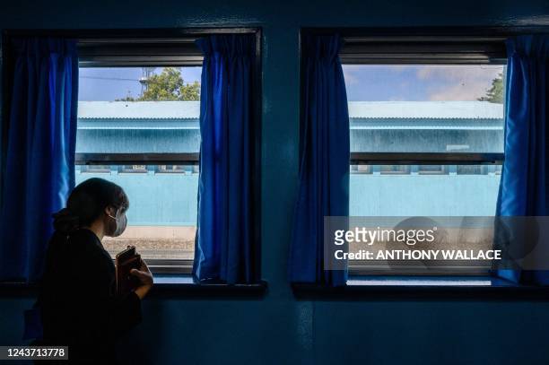 Visitor is pictured from inside a military armistice committee meeting room at the truce village of Panmunjom, as she looks out of a window, in the...