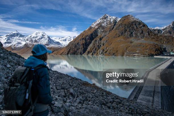 Hiker look at the Grande Dixence dam on October 3, 2022 near Heremence, Switzerland. The dam, which at 285 meters is the tallest in Europe, supplies...