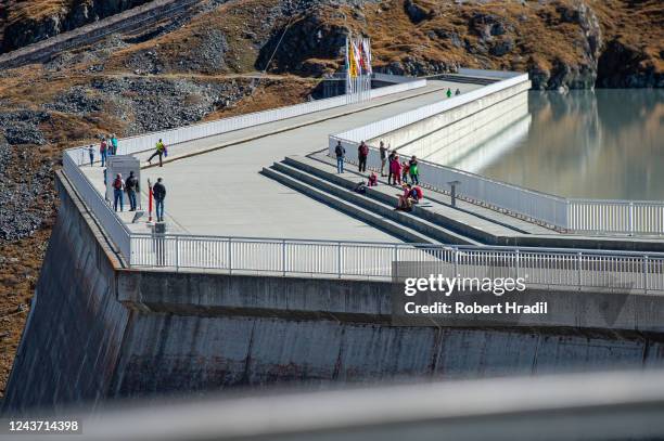 Visitors enjoy their view from the Grande Dixence dam on October 3, 2022 near Heremence, Switzerland. The dam, which at 285 meters is the tallest in...