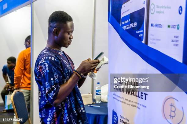 An attendee uses a smartphone by the Vibra booth, operated by African Blockchain Lab, at the Technext Coinference at the Landmark Event Centre in the...