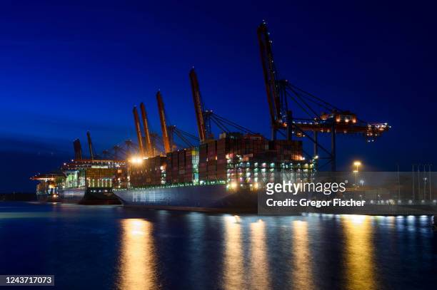 Multiple container ships are docked during blue hour at Container Terminal Burchardkai at Hamburg Port on October 3, 2022 in Hamburg, Germany. The...