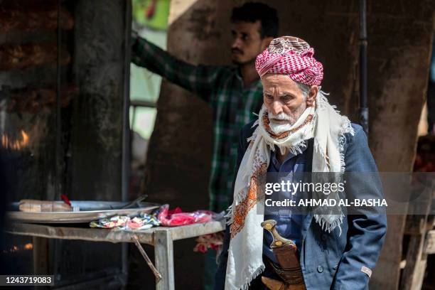 An elderly man walks in an open-air market in Yemen's third city of Taez on October 4, 2022. - The United Nations envoy for Yemen scrambled this week...