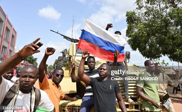 Protesters wave a Russian flag as they demonstrate agaisnt France and the Economic Community of West African States whose representatives are...