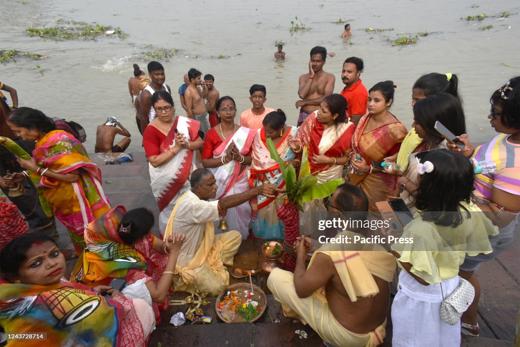 Hindu priests perform prayers in front of a banana tree...