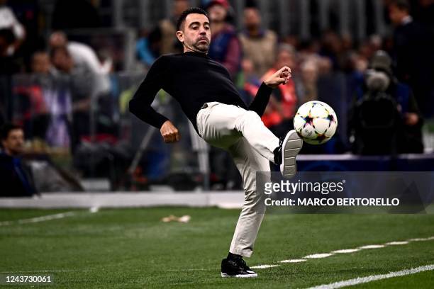 Barcelona's Spanish coach Xavi Hernandez kicks the ball from the touchline during the UEFA Champions League Group C football match between Inter...