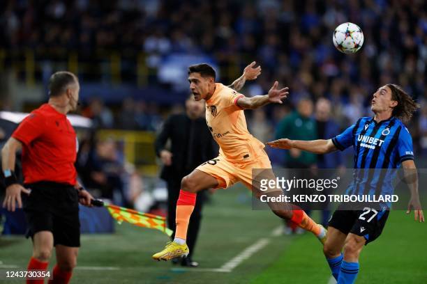 Atletico Madrid's Argentinian defender Nahuel Molina fights for the ball with Club Brugge's Danish midfielder Casper Nielsen during the UEFA...