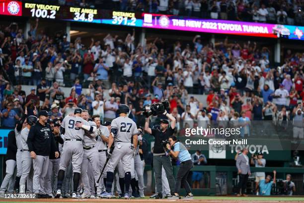 General view as Aaron Judge of the New York Yankees is congratulated by teammates at home plate after hitting his 62nd home run in the first inning...