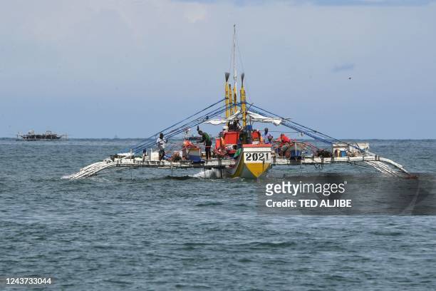 In this photo taken on August 11 a fishing "mother" boat leaves the shores of Cato village in Infanta town, Pangasinan province, for a fishing...