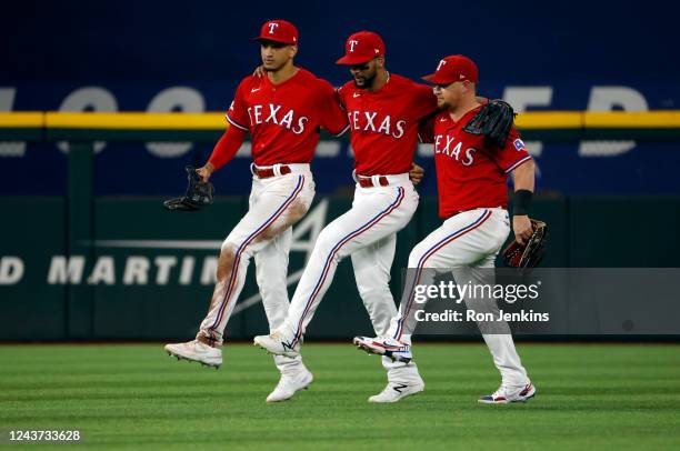 Bubba Thompson of the Texas Rangers and teammates Leody Taveras and Kole Calhoun celebrate their team's 3-2 win against the New York Yankees in game...