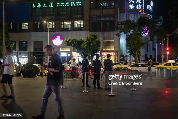Police officers stand near 9th Street, a popular bar and club area in Chongqing, China, on Friday, Aug. 19, 2022. When President Xi Jinping took...