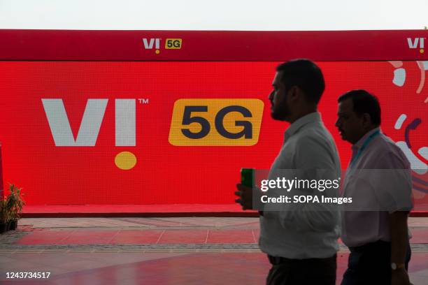 Men walk by a Vodafone idea 5G stall during India Mobile Congress 2022 Exhibition in Pragati Maidan, New Delhi. India Mobile Congress is the largest...