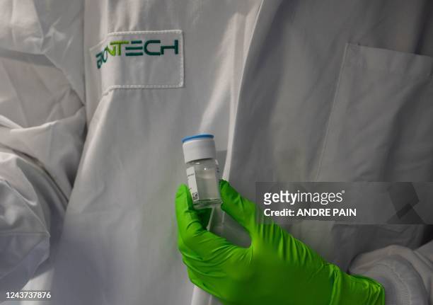 An employee holds up a vial of an oncological product under development, at the BioNTeCH research institute in Mainz, Rhineland-Palatinate, western...