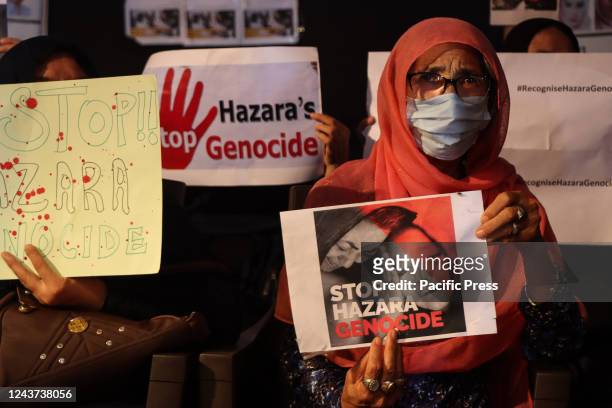 An Afghan woman holds a placard condemning genocide against Hazaras. Afghan refugees living in India stand in solidarity with the victims of Kabul...