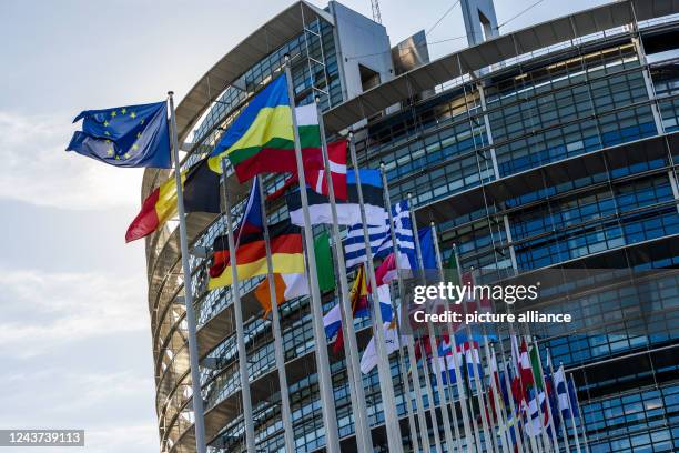 October 2022, France, Straßburg: The flags of the European Union, Ukraine and EU member states fly in front of the European Parliament building in...