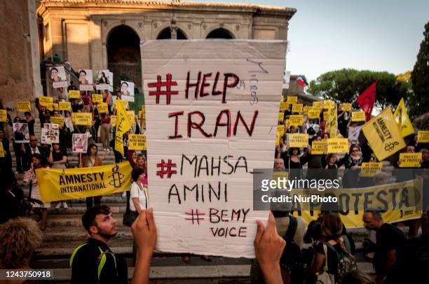 Protesters hold slogans during a demonstration in solidarity with Iranian women and protestors in Piazza del Campidoglio in Rome on October 5...