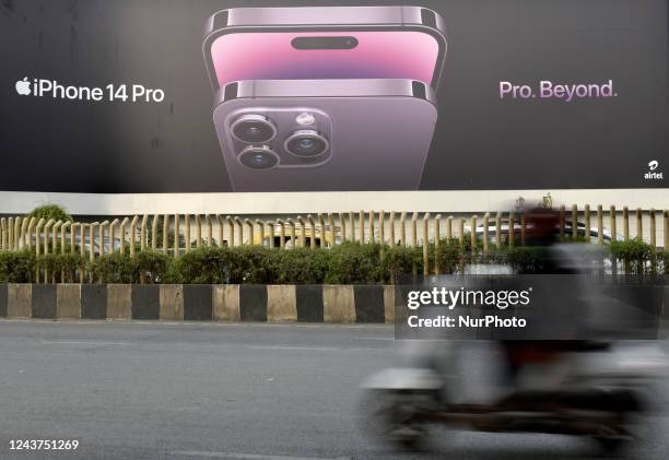 Man rides a scooter passes by an Apple iPhone 14 billboard in Mumbai, India, 05 October, 2022. India's iPhone exports cross 1 Billion dollar in 5...