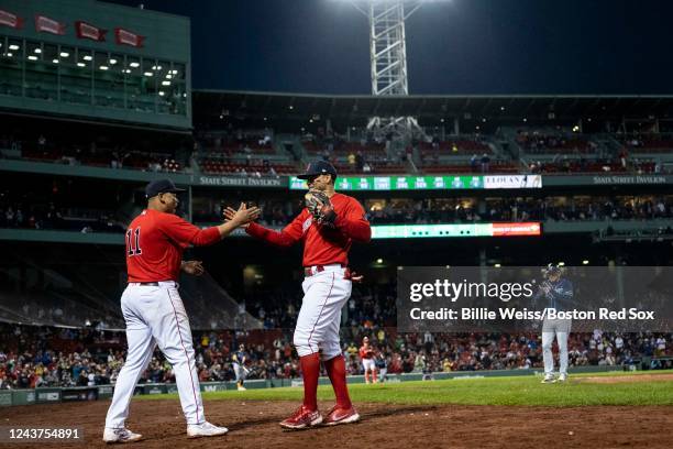 Xander Bogaerts of the Boston Red Sox high fives Rafael Devers as he exits the game during the seventh inning of a game against the Tampa Bay Rays on...