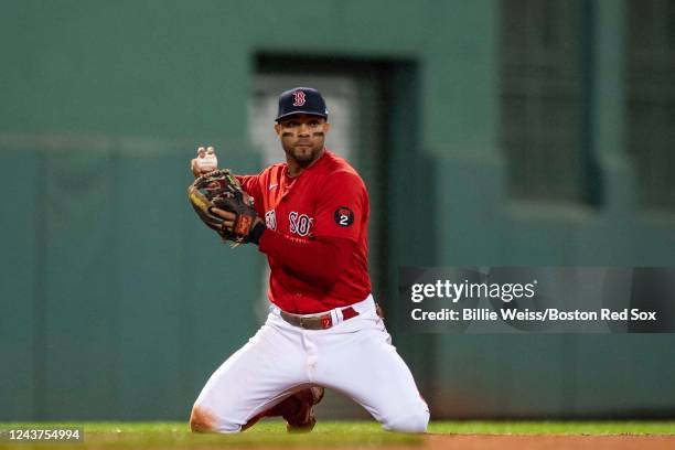 Xander Bogaerts of the Boston Red Sox throws from his knees to begin a double play during the sixth inning of a game against the Tampa Bay Rays on...